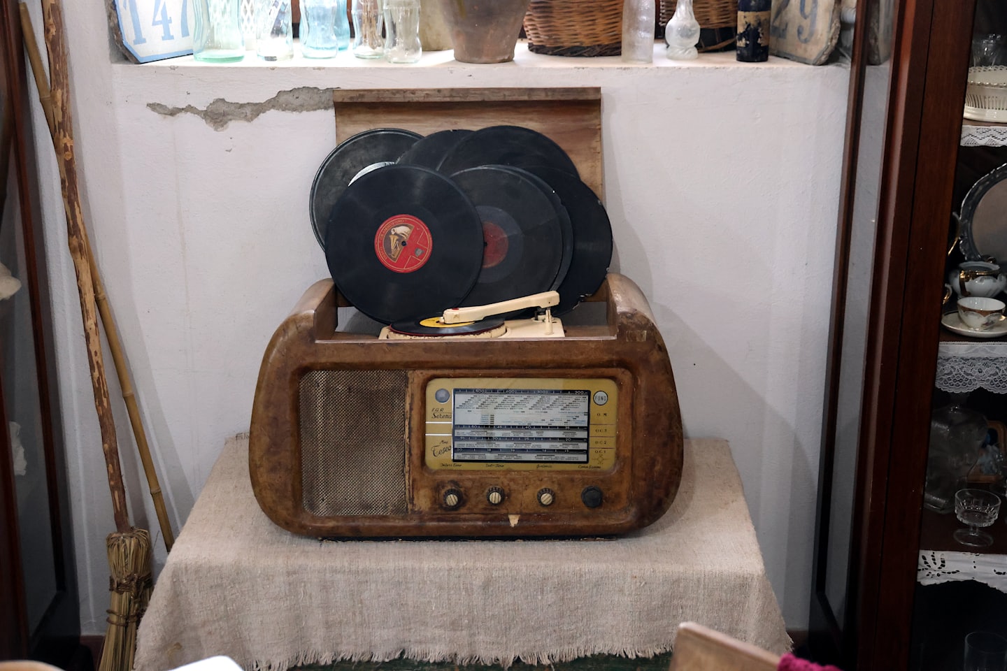 Vintage record player with vinyl records on a linen tablecloth.