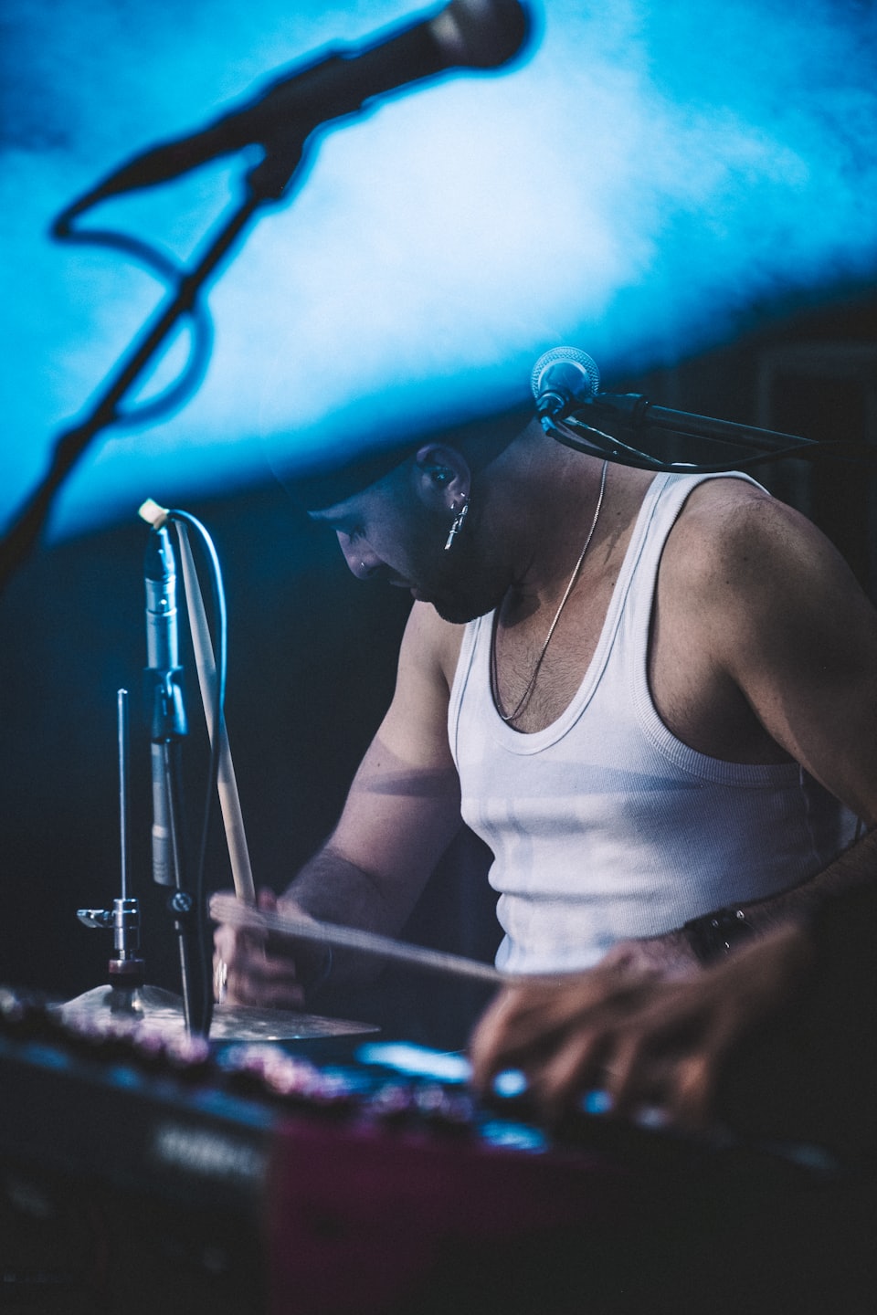 A drummer plays a percussion set on stage.