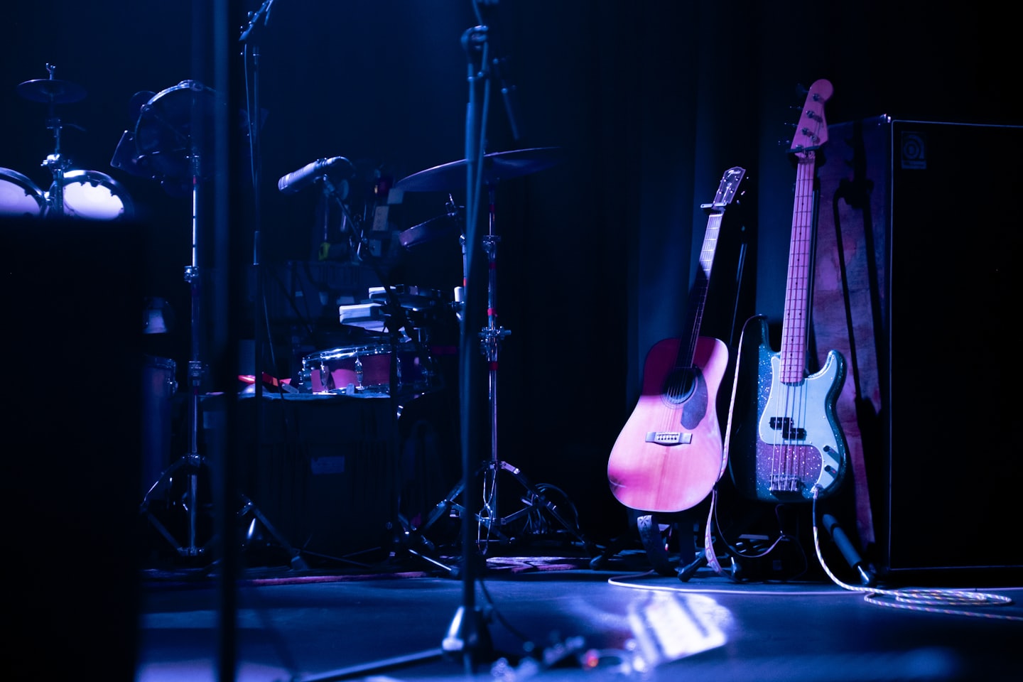 A drum kit and guitars are ready for a performance.