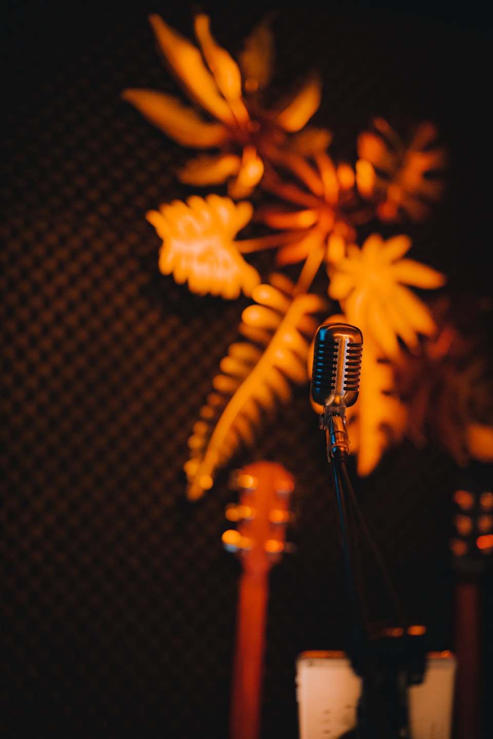 A vintage silver microphone stands ready in a recording studio.